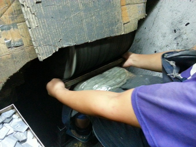 中国広東省東莞市 金属製品加工工場 バッチを研磨機で磨く様子
