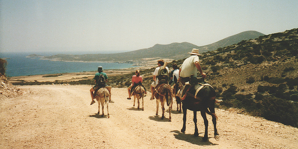 People riding donkeys in Antiparos island - Aegean Sea, Greece.