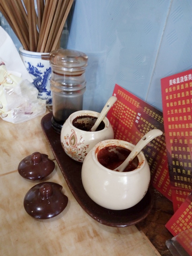 中国 上海虹口 上海外国語大学付近のラーメン店のテーブルに備え付けの調味料 豆板醤