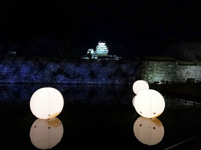 Himeji Castle and lights floating in the moat.